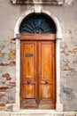 Vintage wooden door on an old wall with exposed bricks