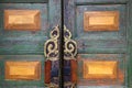 A vintage wooden door with a pair of beautiful handles