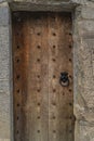 Vintage wooden door with stone frame, cast iron doorhandle and iron studs Royalty Free Stock Photo