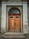 Vintage wooden door and weathered facade details of an old historical building. Outdoors architecture elements. Rustic doorway Royalty Free Stock Photo