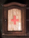 Vintage wooden first aid kit cabinet with glass door and red cross sign Royalty Free Stock Photo