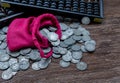 Vintage wooden hand abacus with pile of money coins from red cloth bag on rustic old wooden table Royalty Free Stock Photo