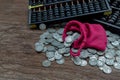 Vintage wooden hand abacus with pile of money coins from red cloth bag on rustic old wooden table Royalty Free Stock Photo