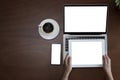 Vintage wooden hipster desktop top view cup of coffee, woman hands using laptop, smartphone and holding tablet screen Royalty Free Stock Photo