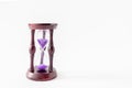 Vintage wooden hourglass with violet sand on white background. Space for text Royalty Free Stock Photo