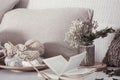 Vintage wooden knitting needles and threads on a cozy sofa with pillows and a vase of flowers. Open book for reading Royalty Free Stock Photo