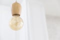 Vintage wooden light bulb hanging on white background. Royalty Free Stock Photo