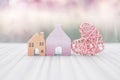 Vintage wooden miniature house with pink wooden heart design over blurred background