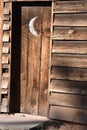 Vintage wooden outhouse with crescent moon on door Royalty Free Stock Photo