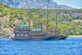 Vintage wooden pirate schooner in the open ocean against the background of the sea horizon. Tourist cruises in the Mediterranean