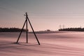 vintage wooden power line pole installed in a snow-covered field in the countryside Royalty Free Stock Photo
