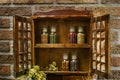 Vintage Wooden Spice Rack or Storage Cabinet and six glass bottles Royalty Free Stock Photo