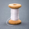 Vintage wooden spool of white sewing thread