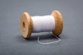 Vintage wooden spool of white sewing thread