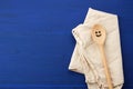 Vintage wooden spoon and white textile kitchen towel on blue wooden background Royalty Free Stock Photo
