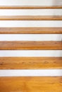 Vintage wooden stair with brown plank tread and white riser. Wood shelf on white painted wall