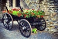 Vintage wooden wain decorated with blooming red geranium Royalty Free Stock Photo