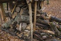 Vintage woodpile-a cage of wooden pegs, beams and roof over them inside in several levels stacked woodpile of sawn boards a stumps