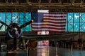 Vintage World War 2 airplane parked inside of an aircraft hanger with a USA flag in the background Royalty Free Stock Photo