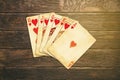 Vintage worn out hearts royal flush poker cards wooden table top