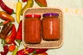 vintage woven wooden basket with two jars of ajvar, traditional Serbian dish of roasted peppers and eggplant Royalty Free Stock Photo