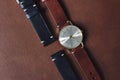 Vintage wristwatch on a brown leather background. Classic watch straps.