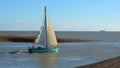Vintage yacht leaving the estuary of the river Deben at Felixstowe Ferry. Royalty Free Stock Photo