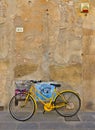 Vintage yellow bicycle in front stone wall on the street in the medieval village of San Sepolcro near city of Arezzo i