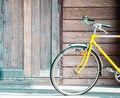 Vintage yellow bicycle on old wooden wall background. Lifestyle concept idea Royalty Free Stock Photo