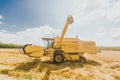 Combine harvester working on large oat field on a sunny day Royalty Free Stock Photo