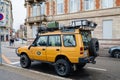 vintage yellow Land Rover Defender Camel Trophy parked in city