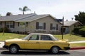 Vintage yellow Mercedes parked on the side of a road by a house in Northridge, Los Angeles