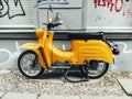 Vintage yellow motor scooter parked on footpath