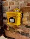 Vintage yellow postbox outdoors on the wall