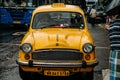 Vintage yellow taxi waiting for passenger near Mullick Ghat Flower Market in Kolkata, India