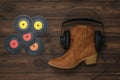 Vinyl discs, boots, headphones on a wooden background.
