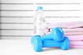 Vinyl dumbbells, bottle of water and towels on table