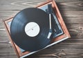 Vinyl player with plates on a wooden table. Entertainment 70s. Royalty Free Stock Photo