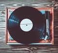 Vinyl player with plates on a wooden table. Entertainment 70s. Listen to music. Top view. Royalty Free Stock Photo