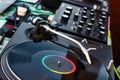 Vinyl record on a deejay`s turntable with mixing desk equipment sound system