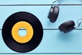 Vinyl record and a headphone on blue wooden background Royalty Free Stock Photo