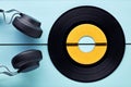 Vinyl record and a headphone on blue wooden background Royalty Free Stock Photo
