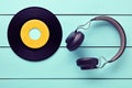Vinyl record and a headphone on blue wooden table background Royalty Free Stock Photo