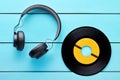 Vinyl record and a headphone on blue wooden table background Royalty Free Stock Photo