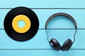 Vinyl record and a headphone on blue wooden table Royalty Free Stock Photo