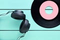 Vinyl record and a headphone on turquoise wooden background Royalty Free Stock Photo