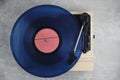 Vinyl record player with blue record installed top view gray background Royalty Free Stock Photo