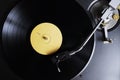 Vinyl record with yellow label playing on a turntable