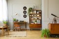 Vinyl records decorations on a gray wall with molding and wooden furniture in a retro home office interior for a writer. Real phot