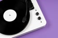 Vinyl turntable with vinyl plate on a purple background. Modern gramophone record player. Retro sound technology to play music Royalty Free Stock Photo